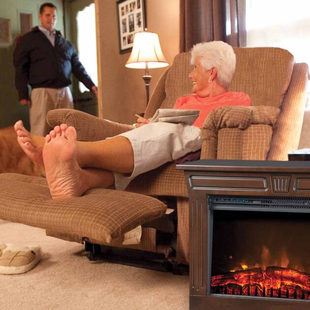 A womand relaxing in her easy-chair with a Heat-n-Glow next to her